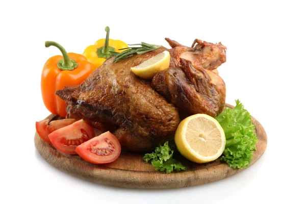 Целый жареный цыпленок на деревянной тарелке с овощами, изолированные на белом — стоковое фото