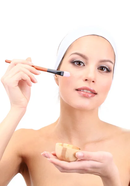 Young woman applying clay facial mask, isolated on white — Stockfoto