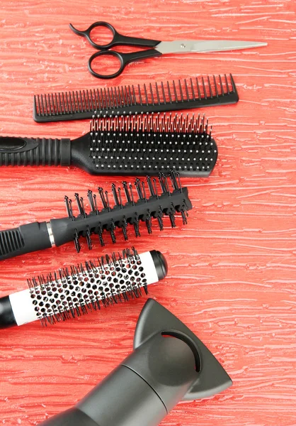 Comb brushes, hairdryer and cutting shears,on color background — Stock Photo, Image