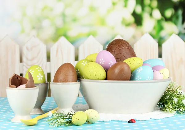 Composition des œufs de Pâques et de chocolat sur fond naturel — Photo