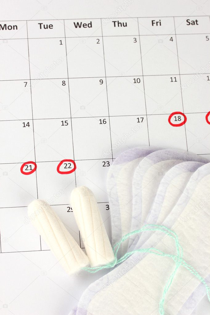 menstruation calendar with sanitary pads and tampons, close-up