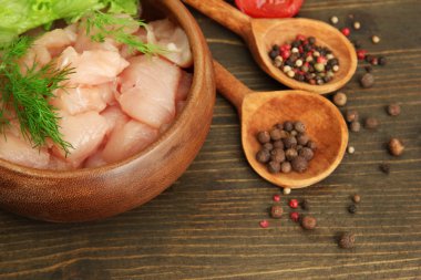 ahşap zemin üzerinde kase çiğ tavuk eti