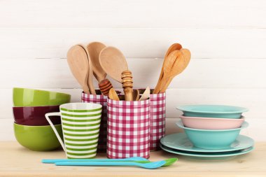 Cups, bowls nd other utensils in metal containers isolated on light background