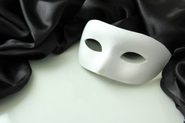 Beyaz maske ve siyah ipek kumaş üzerine beyaz izole,