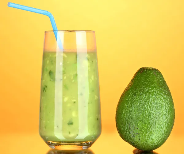 Abacate fresco útil sobre fundo laranja — Fotografia de Stock