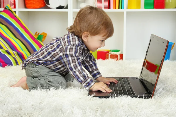 Cute little boy and notebook in room — Stock Photo, Image