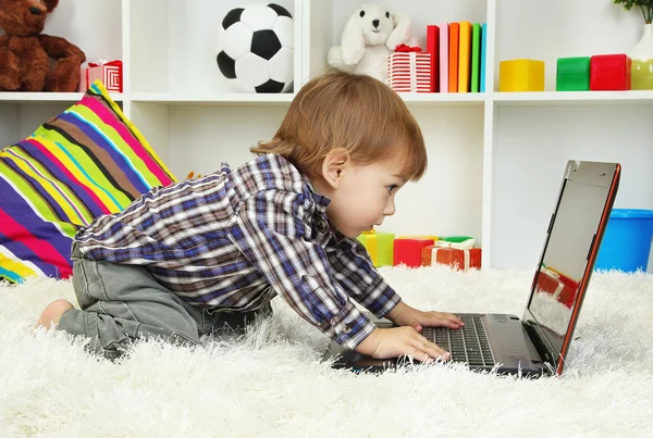 Cute little boy and notebook in room — Stock Photo, Image