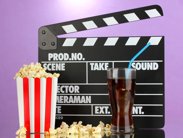 Film clapperboard, cola i popcorn na fioletowym tle — Zdjęcie stockowe