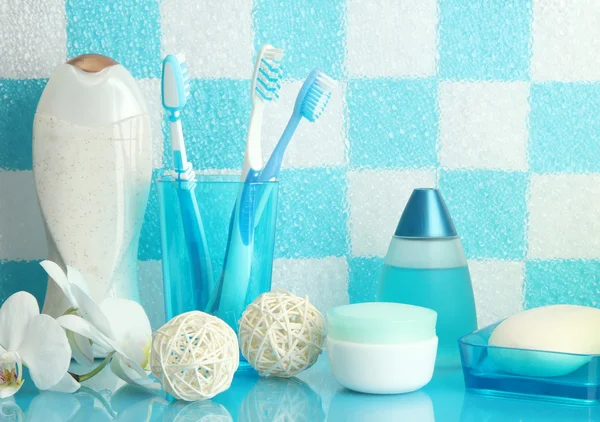 Accesorios de baño en el estante en el baño sobre fondo de pared de azulejo azul —  Fotos de Stock