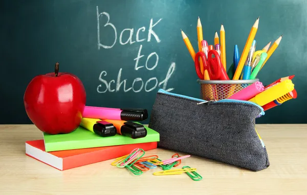 Terug naar school - bord met potlood-box en school apparatuur op tafel — Stockfoto