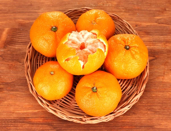 Chutné mandarinky na proutěné podložky na dřevěné pozadí — Stock fotografie