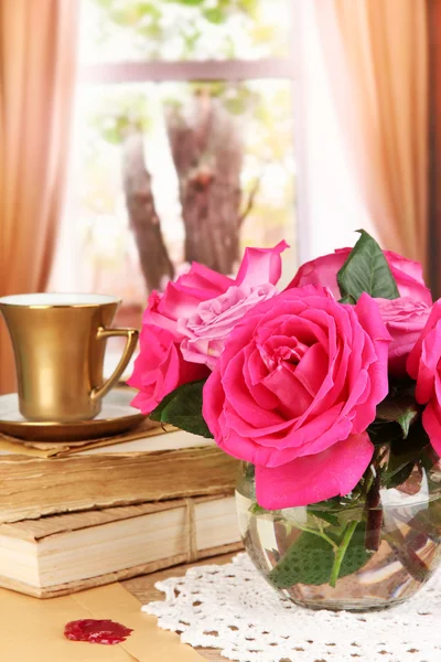 Beautiful pink roses in vase on wooden table on window background — Stock Photo, Image