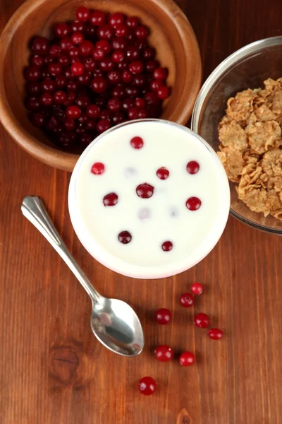 Glass of yoghurt dessert with berries, on wooden background — Stock fotografie