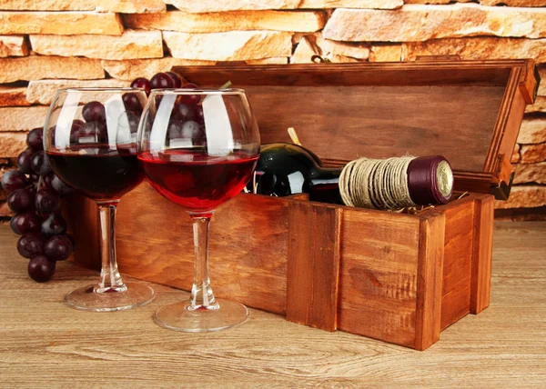 Composición de vino, caja y uvas en la mesa sobre fondo de pared de ladrillo — Foto de Stock