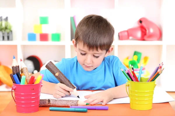 Симпатичный маленький мальчик рисует в альбоме — стоковое фото