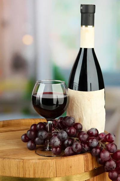 葡萄酒瓶、 玻璃、 葡萄、 木制桶，在明亮的背景上的组成 — 图库照片