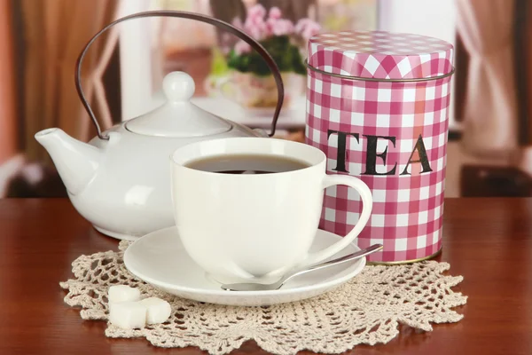 Jar and cup of tea on table in room — Stock Photo, Image