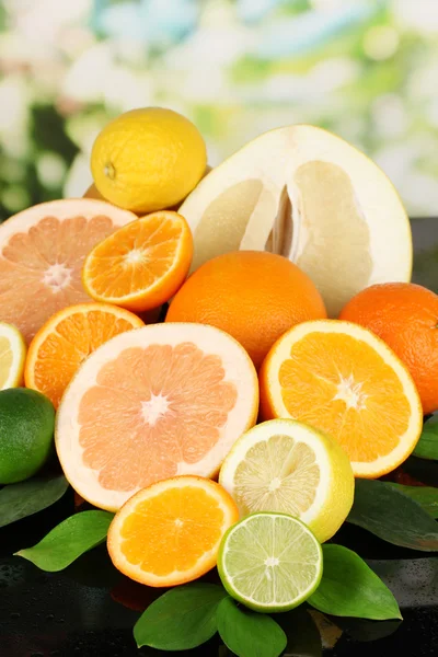 Veel rijp citrus op zwarte tafel op natuurlijke achtergrond — Stockfoto