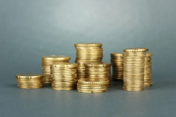 Muitas moedas em colunas sobre fundo cinza — Fotografia de Stock