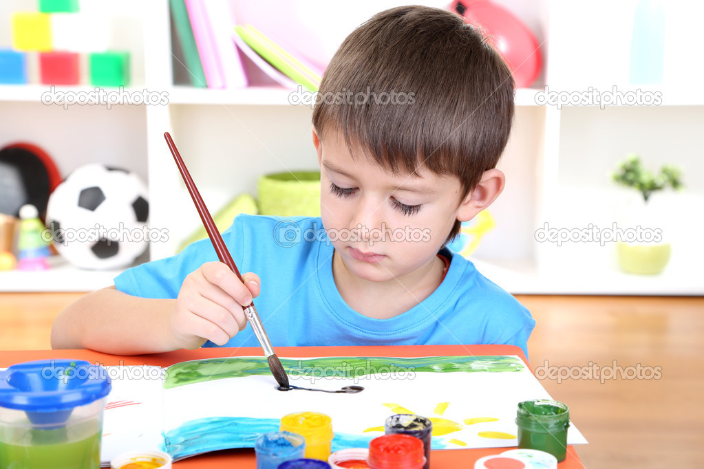 Cute little boy painting in his album — Stock Photo © belchonock #19504085