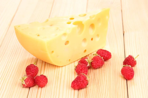 Smakelijke kaas en bessen op houten achtergrond — Stockfoto