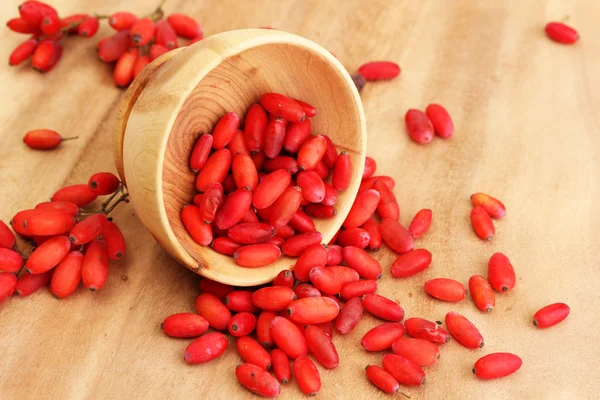 Ripe barberries in wooden bowl, on wooden background — Stock Photo, Image