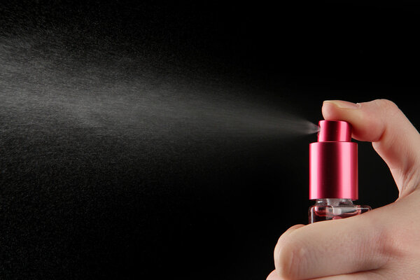 женские духи в бутылке и распыления, на черном фоне
