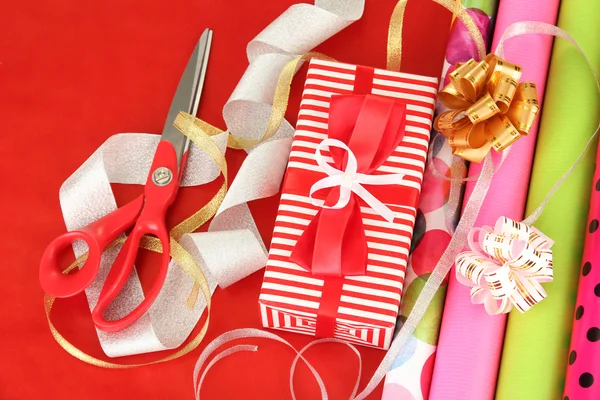 Rotoli di carta da regalo di Natale con nastri, fiocchi su sfondo a colori — Foto Stock