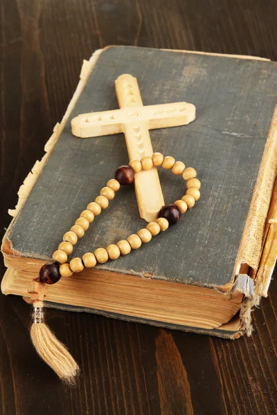 Bible, růženec a kříž na dřevěný stůl detail — Stock fotografie