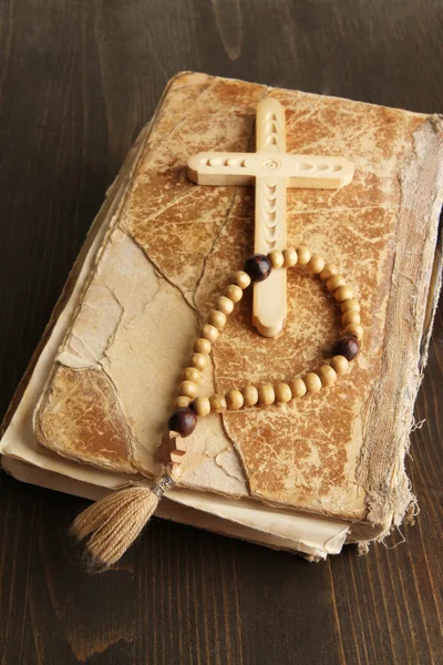 Bible, rosary and cross on wooden table close-up — Stock Photo, Image