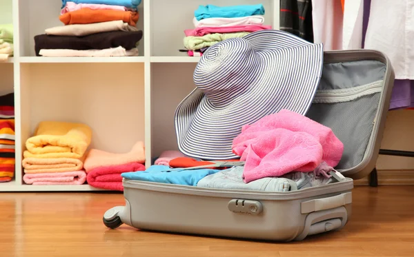 Открытый серебряный чемодан с одеждой в номере — стоковое фото