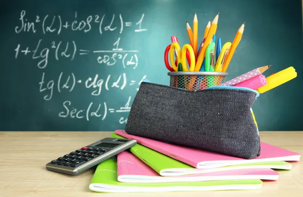 Voltar à escola - quadro-negro com caixa de lápis e equipamento escolar na mesa — Fotografia de Stock