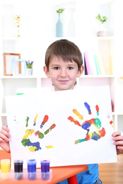 Süßer kleiner Junge mit seinem bunten Handabdruck — Stockfoto