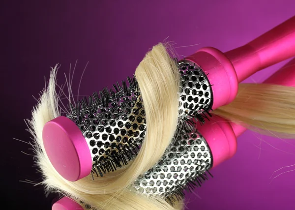 Kam borstel met haren op paarse achtergrond — Stockfoto