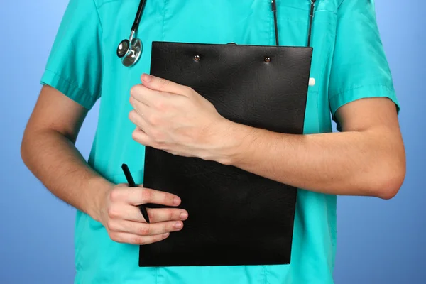 Mano del médico con receta en blanco, sobre fondo azul — Foto de Stock