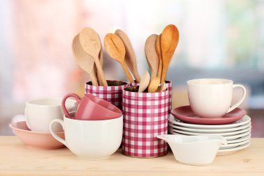Cups, bowls nd other utensils in metal containers isolated on light background
