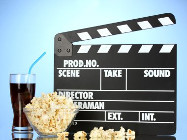 Film Klaket, cola ve mavi arka plan üzerinde patlamış mısır