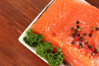 bitkiler ve ahşap zemin üzerinde plaka üzerinde limon dilimleri ile taze somon fileto