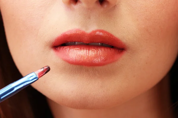 Mooie vrouw toepassing lipgloss, close-up — Stockfoto