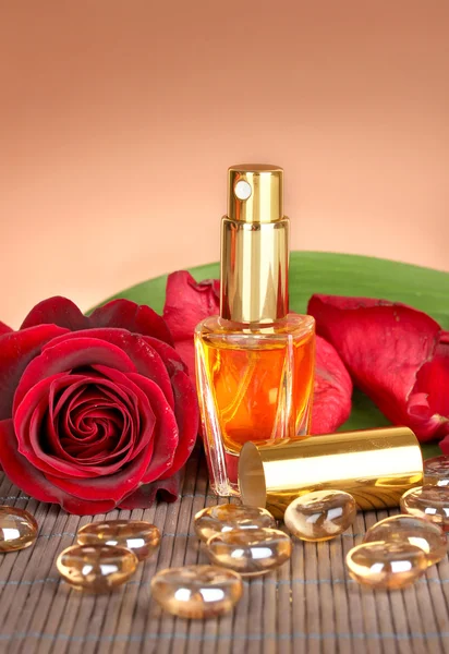 Vrouw perfume in mooie fles met roos op bruine achtergrond — Stockfoto