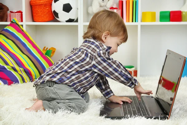 Lindo niño y portátil en la habitación —  Fotos de Stock