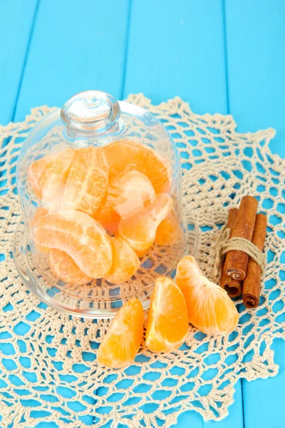 Tangerine's slices on saucer under glass cover on blue background — Stock Photo, Image