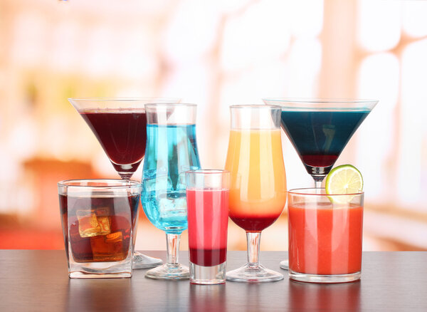 Several glasses of different drinks on bright background