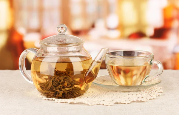 Екзотичний зелений чай з квітами в скляному чайнику на яскравому фоні — стокове фото