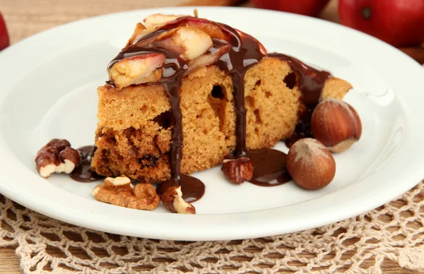 Slice of tasty homemade pie with chocolate and apples, on wooden table — Stock Photo, Image