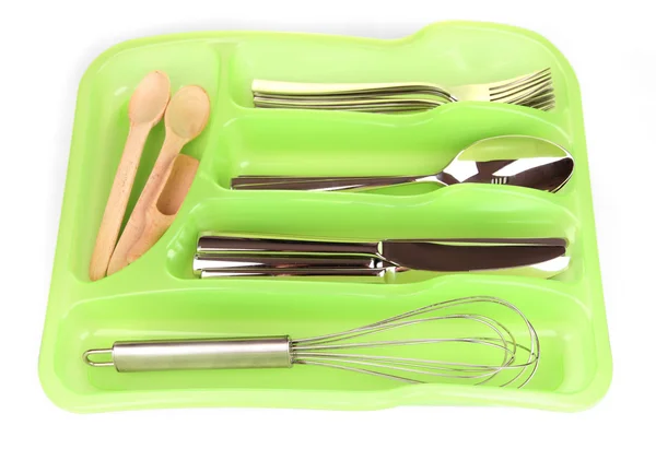 Green plastic cutlery tray with checked silver cutlery and wooden spoons isolated on white — Stock Photo, Image