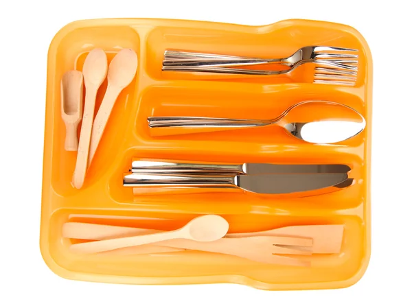 Πορτοκαλί πλαστικά μαχαιροπήρουνα δίσκο με ελεγμένη ασημένια μαχαιροπίρουνα και ξύλινα κουτάλια που απομονώνονται σε λευκό — Φωτογραφία Αρχείου