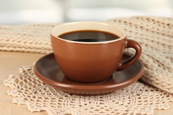 Tazza di caffè con sciarpa sul tavolo in camera — Foto Stock