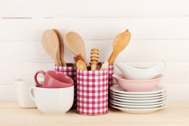 Cups, bowls nd other utensils in metal containers isolated on light background