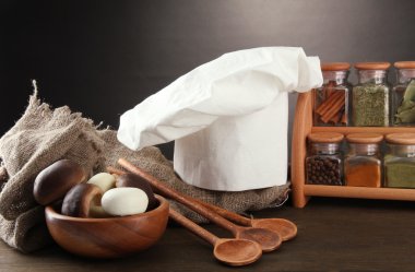 Şef'in şapkası ve kitchenwear tabloda gri arka plan üzerinde kompozisyonu
